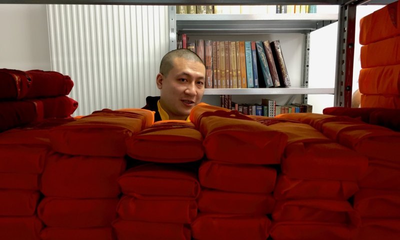 Thayé Dorjé, Sa Sainteté le XVIIᵉ Gyalwa Karmapa en visite à la bibliothèque avec l’équipe de bibliothécaires, lors de sa venue à Dhagpo Kagyu Ling en 2023  Dhagpo Kagyu Ling   Bouddhisme   Programme   Actualités   Ressources   Soutenir   Informations pratiques   50 ans   Français 50 ans d'Histoire Naissance d’une bibliothèque Ligne du temps Vous êtes idi : Accueil / Bouddhisme / 50 ans d’histoire / Naissance d’une bibliothèque  Sa Sainteté le XIVᵉ Künzik Shamarpa, Mipham Chönyi Lodrö, lors de l’inauguration de la bibliothèque, le 13 juin 2013, en présence des représentants de l’état Rangjung Rikpé Dorjé, Sa Sainteté le XVIᵉ Gyalwa Karmapa, a expliqué que l’existence d’une bibliothèque est l’une des cinq ressources – clés pour que le bouddhisme prenne racine là où il n’existait pas auparavant.  La Bibliothèque Dhagpo Kagyu a donc pour mission de sauvegarder un corpus bouddhique unique, à l’avenir assez incertain dans son pays d’origine et de rechercher des textes perdus parfois réédités à très peu d’exemplaires au Tibet, en Inde, en Chine ou ailleurs dans le monde. Si la préservation est capitale, elle ne constitue pas une fin en soi : le but est de mettre ce savoir à la disposition du plus grand nombre.  Dans notre contexte occidental, rares sont les personnes nées bouddhistes. Nous le devenons, pas à pas, en apprivoisant la compréhension du message du Bouddha et en l’appliquant. Le Bouddha a vécu il y a plus de 2500 ans ; comment son message et sa méthode nous sont-ils parvenus ? Grâce aux pratiquants accomplis et à leurs écrits.  Les premiers disciples de l’Éveillé ont minutieusement consigné ses enseignements à la main. Ces textes ont ensuite été commentés, traduits, publiés – en d’autres termes rendus accessibles et transmis.  Dans la lignée karma kagyü, le livre n’est pas un objet de vénération mais un instrument de compréhension et de rappel sur le chemin. Le pratiquant s’inscrit dans une tradition, applique et approfondit l’enseignement d’un enseignant qualifié afin de s’imprégner de cet héritage jusqu’à ce qu’il devienne sien. L’humain transmet et le livre joue le rôle de support, de mémoire, condition sine qua non de la transmission.  Quand la Bibliothèque Dhagpo Kagyu est-elle née ? Tout a vraiment commencé un jour d’avril 2000 quand une collection de textes tibétains est arrivée sous la forme de 37 000 microfilms.  De la guerre froide aux livres pour la paix En pleine guerre froide, un programme américain d’aide alimentaire appelé Public Law 480 (PL 480) a été créé à des fins diplomatiques dans divers pays du monde entier, dont l’Inde. À la fin des années 1950, un Américain du nom de Gene Smith (1936-2010) travaillait à New Delhi pour le compte de la Library of Congress (Bibliothèque du Congrès) de Washington. Il consacrait la plus grande partie de son temps à essayer de récupérer des textes bouddhiques perdus lors de l’invasion du Tibet par la Chine, et à effectuer des copies des livres qui lui parvenaient. Un programme de la taille et de l’importance de la PL 480 pouvait certainement servir pour soutenir la publication des textes tibétains recueillis, mais quel rapport la publication de textes anciens avait-elle avec la distribution de nourriture ?  Gene Smith proposa d’étendre ce programme d’aide alimentaire à « la nourriture de la pensée », c’est-à-dire de faire en sorte que la Bibliothèque du Congrès puisse acquérir des textes tibétains par l’intermédiaire du programme PL 480. Une fois les défis administratifs relevés, Gene Smith, avec l’aide de nombreux maîtres éminents de l’époque, comme Dilgo Khyentsé Rinpoché (1910-1991), Düjom Rinpoché (1904-1987) et de nombreux autres, a pu recueillir ces trésors de l’humanité menacés de disparition et apportés de l’Himalaya depuis le Tibet, le Bhoutan ou le Népal. Il organisa l’impression de ces textes anciens par des moyens photomécaniques afin qu’ils puissent être transformés en nouvelles publications disponibles à l’achat. C’est une méthode  primitive pour la production de livres selon les normes actuelles, mais une solution indéniablement brillante. Le but était non seulement de préserver de la disparition ces livres en danger, mais aussi d’encourager leur publication pour les générations futures.  Ces textes de toutes les traditions du bouddhisme tibétain ont été sauvegardés en premier lieu grâce aux pratiquants tibétains qui les ont emportés en exil au prix de leur vie. Le travail et l’ingéniosité de Gene Smith ont permis de les préserver et de les rendre accessibles.  Puis, ces textes ont été mis sous forme de microfilms par l’Institute for Advanced Studies of World Religions (l’Institut des hautes études des religions du monde), à New York, à des fins de préservation. Grâce à l’immense générosité d’un mécène, la Bibliothèque Dhagpo Kagyu a acquis une copie de la quasi-totalité de cette collection, soit 37 000 microfilms regroupant quelque 3000 titres d’ouvrages en tibétain, au format occidental ou traditionnel tibétain. Ces microfilms sont consultables à la bibliothèque, sur un scanner dédié à leur lecture et à leur numérisation.  Les année 2000, phase de construction de la bibliothèqueScanner permettant la lecture des microfilmsLecture des microfilmsSon Éminence Jamgon Kongtrul Rinpoche en visite à la bibliothèque avec l’équipe de bibliothécaires, lors de sa venue à Dhagpo Kagyu Ling en août 2024 Lorsque ces microfilms sont arrivés un jour d’avril 2000, lama Jigmé Rinpoché a déclaré :   Nous pouvons à présent dire que nous avons une bibliothèque !  Même si un semblant de bibliothèque existait déjà, notamment grâce au fonds documentaire acheté à Erwan Temple, l’arrivée de ces trésors a constitué une étape importante de son développement.  Sa Sainteté le XIVᵉ Künzik Shamarpa, Mipham Chönyi Lodrö, lors de l’inauguration de la bibliothèque, le 13 juin 2013, en présence des représentants de l’état Ouverte au public depuis le 13 juin 2013, après son inauguration par Mipham Chökyi Lodrö, Sa Sainteté le XIVᵉ Künzik Shamarpa, la Bibliothèque Dhagpo Kagyu abrite aujourd’hui plus de 14 000 documents, en langues tibétaine et occidentales, des milliers d’heures d’enregistrement audio ou vidéo d’enseignements de maîtres aujourd’hui disparus. Tous ces documents sont consultables gratuitement dans la salle de lecture accessible à tous. La bibliothèque ne se limite pas à un seul lieu, mais elle s’étend à un réseau international de bibliothèques en France, en Inde et au Népal. N’hésitez pas à consulter son catalogue en ligne sur son application dédiée et son site Internet. L’équipe de bénévoles se consacre actuellement au projet principal en cours qui est la numérisation de documents audio. Ces documents historiques, témoins des premiers pas du Dharma en Europe, sont préservés et progressivement rendus accessibles dans le fonds documentaire.  Tout lecteur est le bienvenu dans l’espace calme et lumineux de la salle de lecture. Des visites guidées permettent aussi de visiter les fonds documentaires occidental et tibétain.  Salle de lecture de la bibliothèqueSalle de lecture de la bibliothèqueVisite guidée du fonds documentaires (sur demande)Collections du Kangyur et du Tengyur De nombreux enseignants éminents, comme les détenteurs des lignées  karma kagyü et nyingma, en les personnes de Thayé Dorjé, Sa Sainteté le XVIIᵉ Gyalwa Karmapa, et de Sa Sainteté feu Düjom Rinpoché, Leurs Éminences Jamgön Kongtrül Rinpoché et Béru Khyentsé Rinpoché, ont visité cette Bibliothèque Dhagpo Kagyu. Elle est aussi visitée par de nombreux autres érudits tibétains et occidentaux, toujours curieux des nouvelles acquisitions ou des textes anciens ayant été retrouvés.   Thayé Dorjé, Sa Sainteté le XVIIᵉ Gyalwa Karmapa en visite à la bibliothèque avec l’équipe de bibliothécaires, lors de sa venue à Dhagpo Kagyu Ling en 2023
